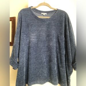 Loose flowing blue shirt with pocket and rolled sleeve detail